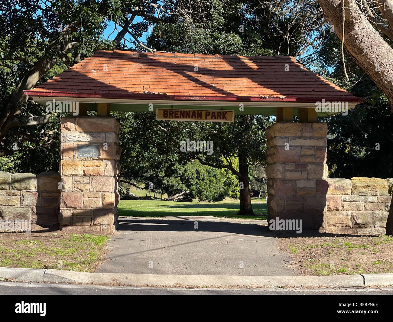 Cancello d'ingresso in pietra arenaria Heritage con tetto in piastrelle di terracotta al Brennan Park, uno storico parco pubblico a Sydney, Australia. - Immagine stock catturata con smartphone