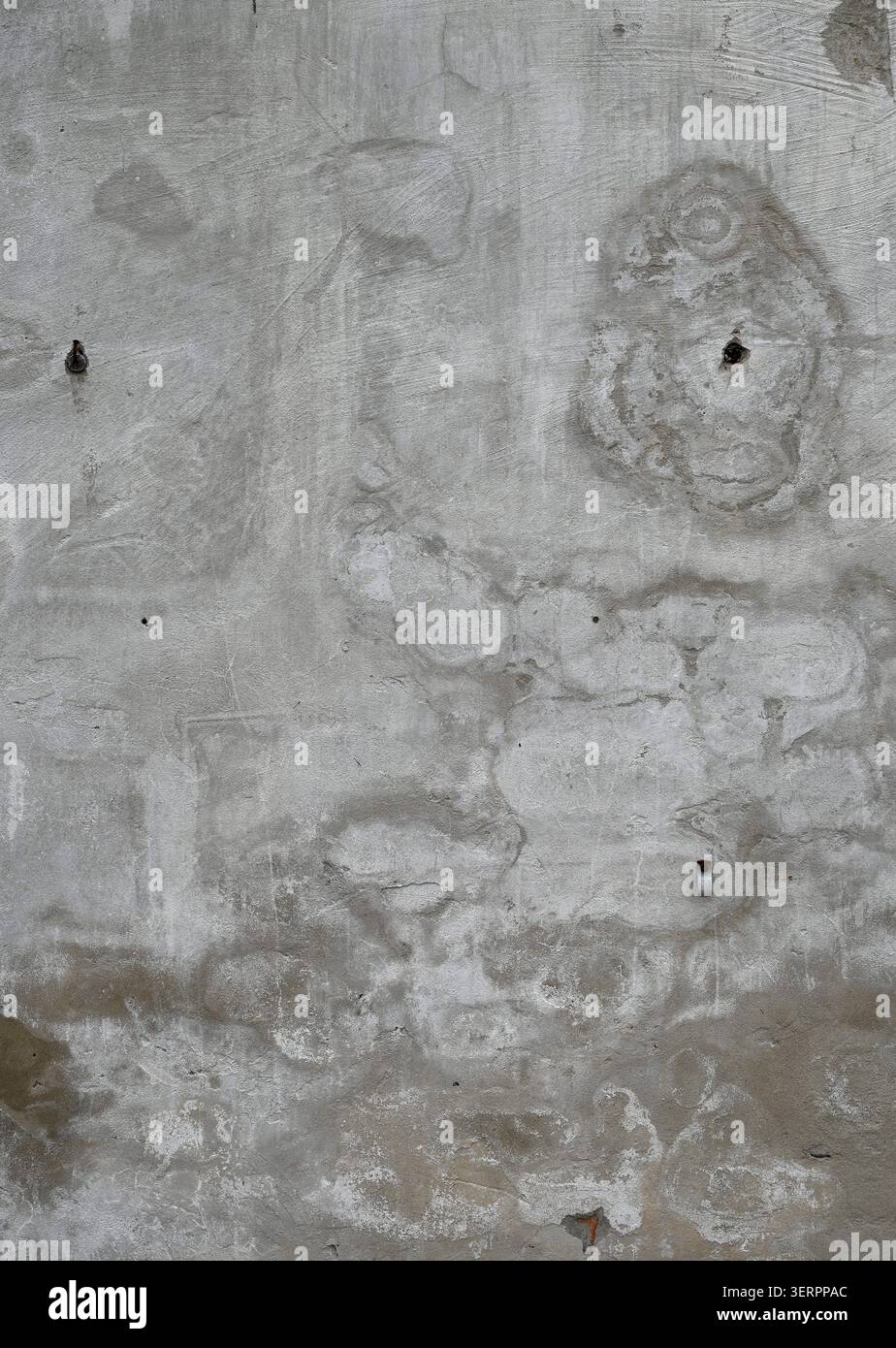 Primo piano verticale di una superficie di parete in cemento intemprato con cemento grezzo poroso e macchie d'acqua Foto Stock