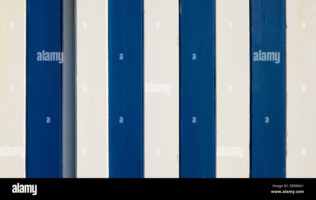 Tavole di legno con alternanza di vernice blu e bianca che creano una texture di sfondo a righe sulla porta della capanna sulla spiaggia Foto Stock