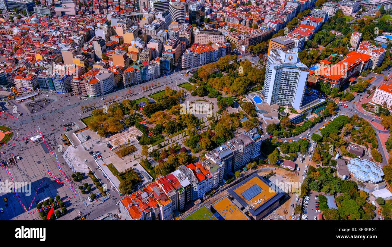 Vista aerea con droni di Piazza Taksim e del Parco Gezi nel quartiere di Beyoğlu con fogliame autunnale e bandiere turche, Istanbul, Turchia Foto Stock
