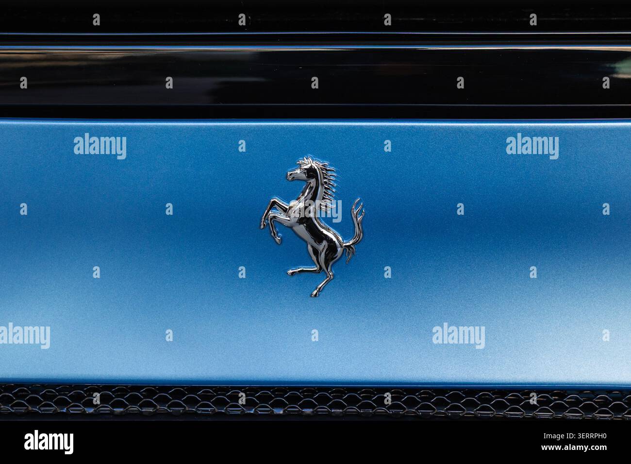 Lubiana, Slovenia - 11 aprile 2026: Il logo Ferrari mostra l'iconico simbolo del cavallo su un'elegante superficie blu Foto Stock