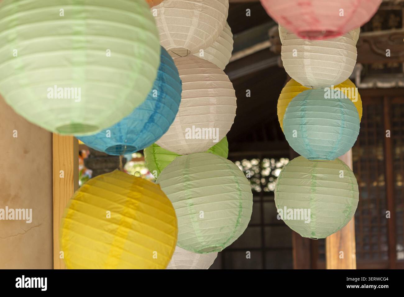 Vista delle colorate lanterne di carta appese di fronte ad un tradizionale edificio tempio in legno con luce soffusa del giorno a Osaka, Osaka, Giappone. Foto Stock