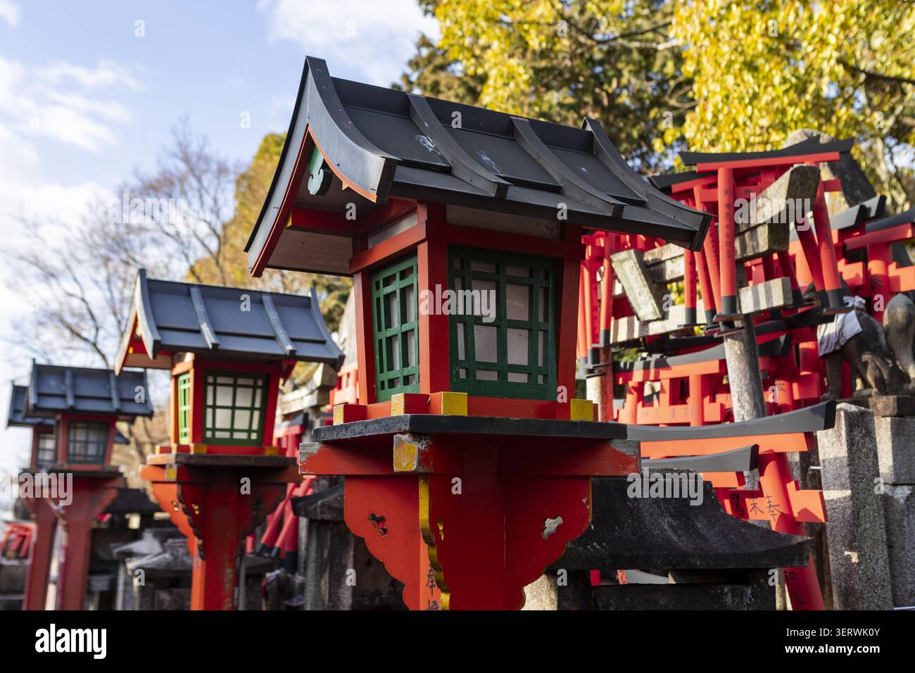 Vista delle tradizionali lanterne rosse e delle porte torii in miniatura al santuario di Fushimi Inari-taisha sotto un cielo limpido Kyoto, Kyoto, Giappone. Foto Stock
