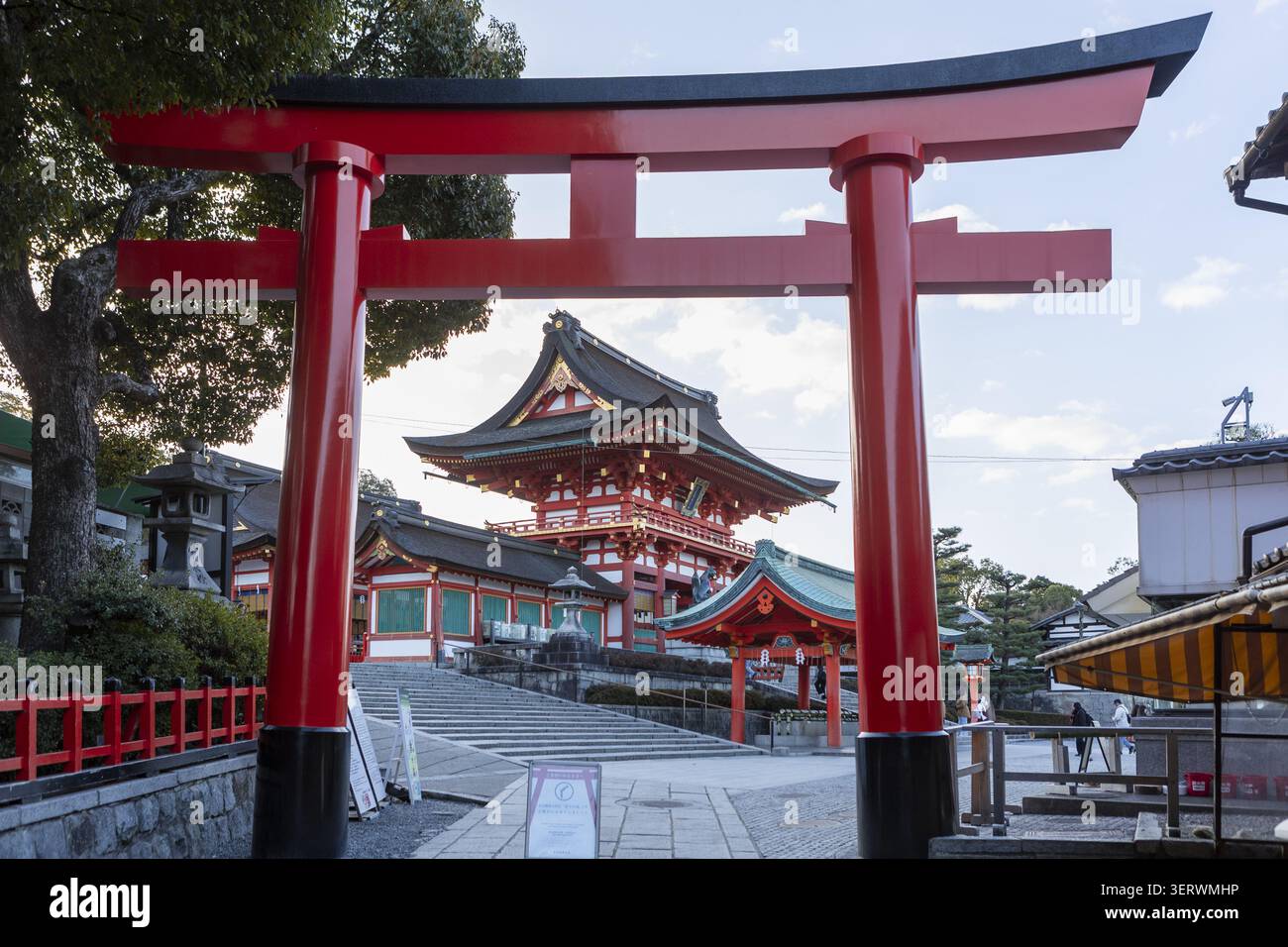 Vista della grande porta torii rossa e della porta Romon al santuario shintoista di Fushimi Inari-taisha sotto un cielo limpido Kyoto, Kyoto, Giappone. Foto Stock