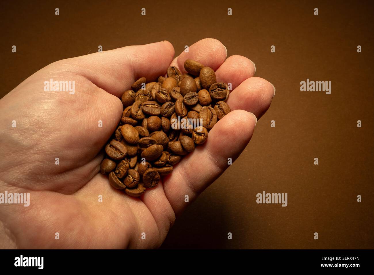 Una manciata di chicchi di caffè tostati. Foto Stock