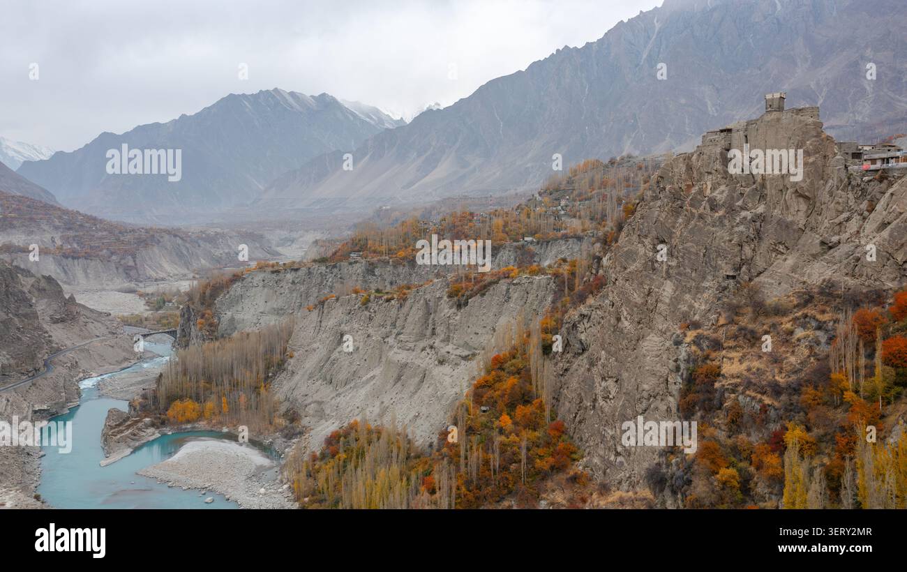 Vista aerea del forte di Altit arroccato su una scogliera rocciosa che si affaccia sul fiume Hunza con fogliame autunnale e montagne sullo sfondo, Altit, Gilgit, Pak Foto Stock