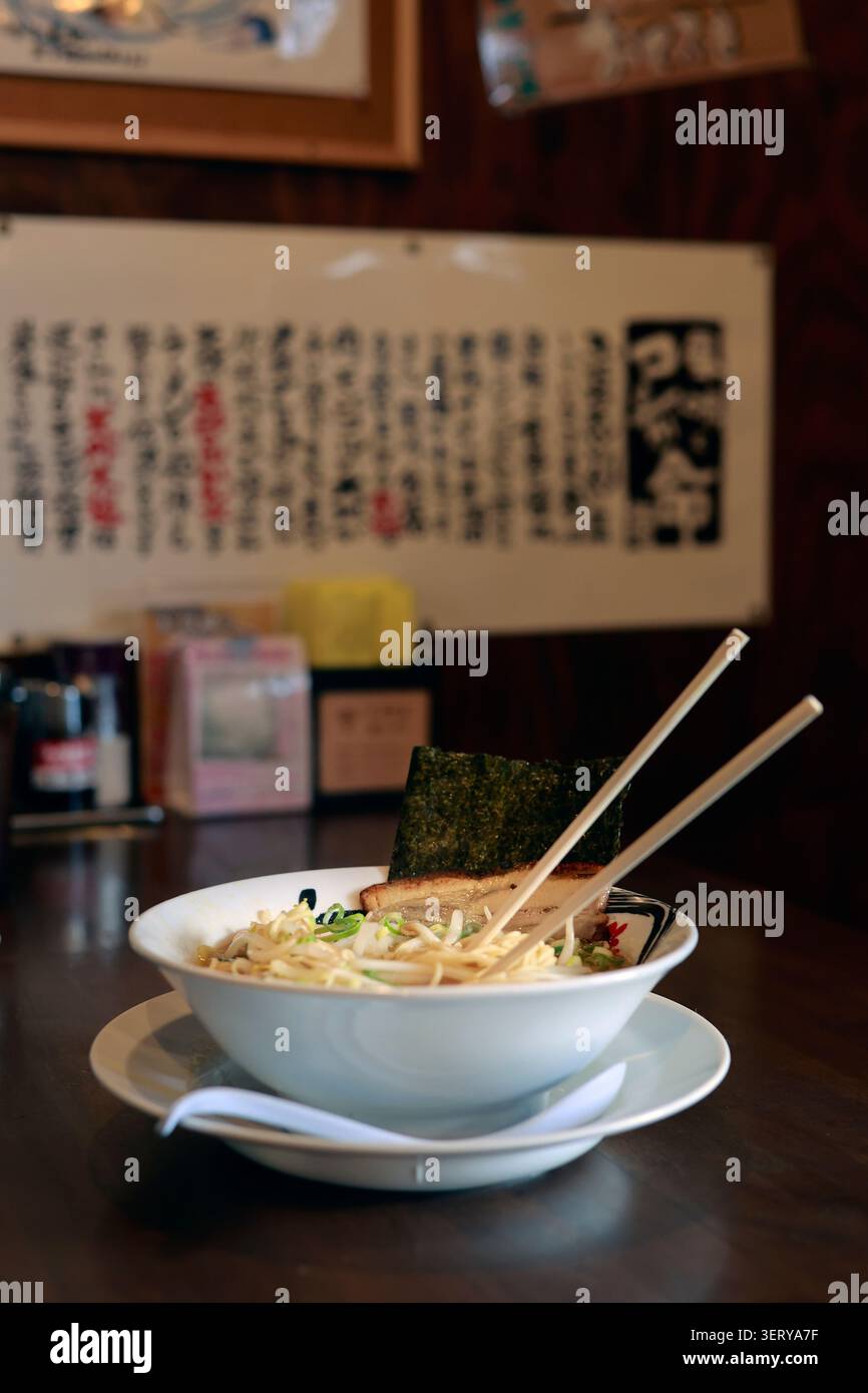 Tradizionale ciotola giapponese di Ramen con Nori di maiale Chashu e bastoncini al ristorante Foto Stock
