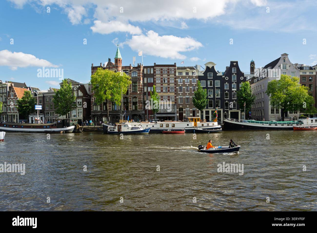 Amsterdam, Paesi Bassi. 22 giugno 2014, Amsterdam Amstel fiume con case e barche sui canali Foto Stock
