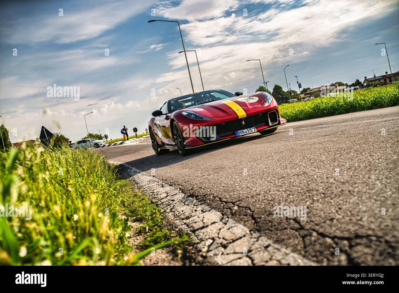 Lusia, italia 10 giugno 2026: Auto sportiva ferrari con una striscia gialla che guida su una strada panoramica italiana durante la storica mille miglia endur Foto Stock