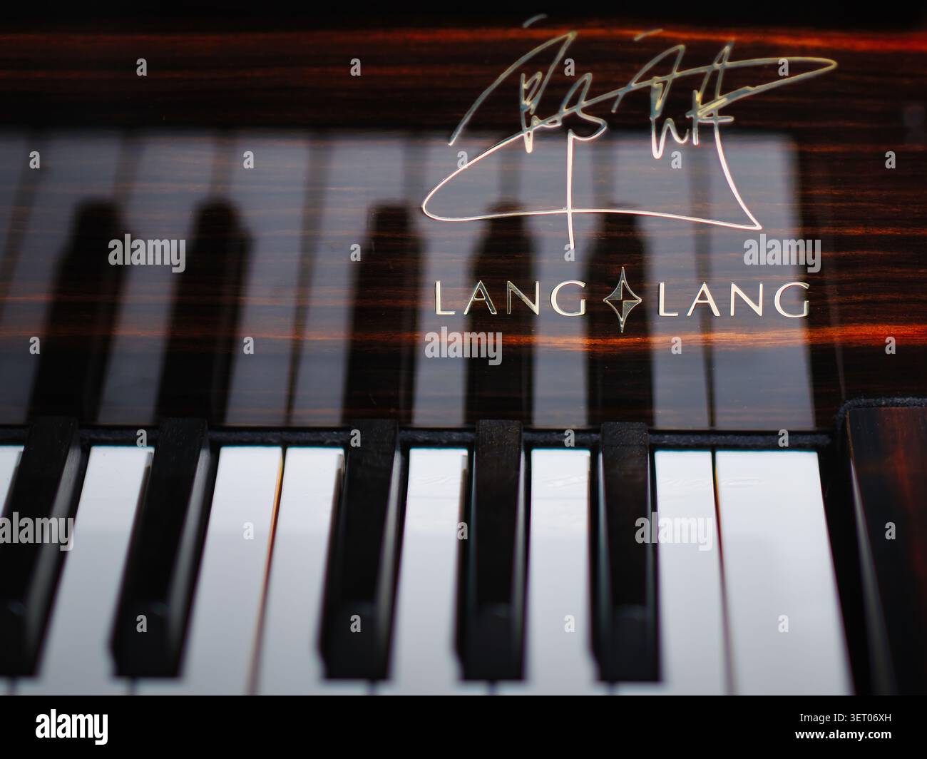 Firma e logo di Lang Lang su un pianoforte, primo piano di tasti bianchi e neri con messa a fuoco selettiva Foto Stock