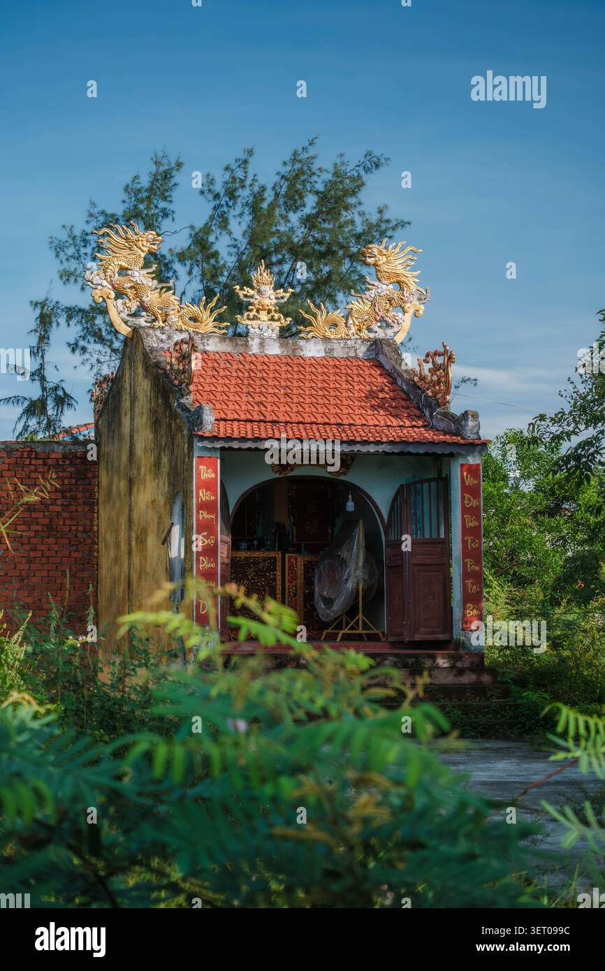 Tradizionale edificio di santuario asiatico con statue di draghi dorati sul tetto Foto Stock