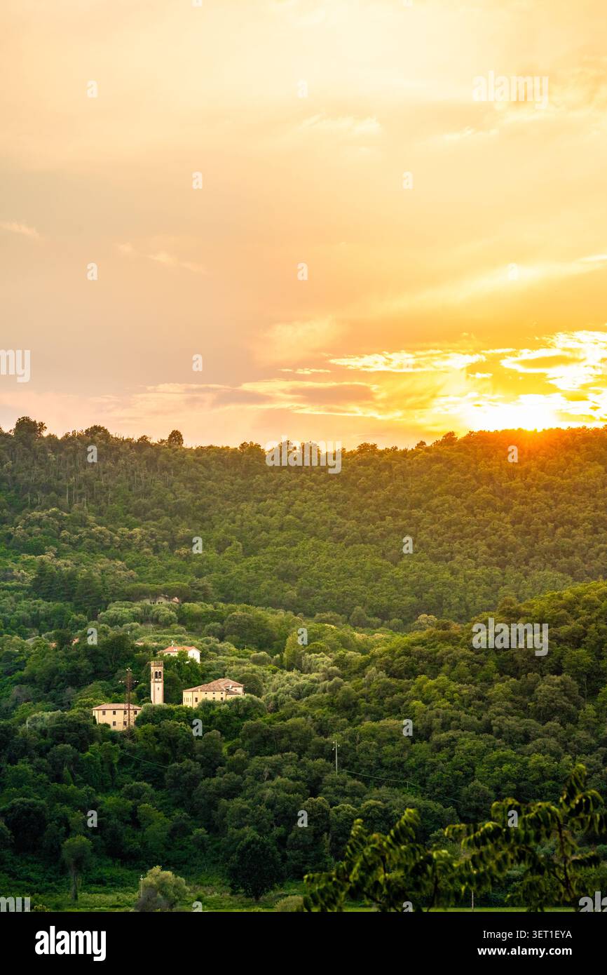 Torre della Chiesa in una valle di verdi colline dei Colli Euganei al tramonto del paesaggio rurale italiano Foto Stock