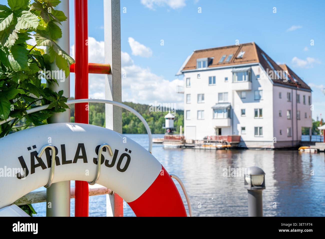 Boa con il nome della zona residenziale Järla Sjö a Nacka scritto su di esso vicino al lago con condominio sull'acqua in estate Foto Stock