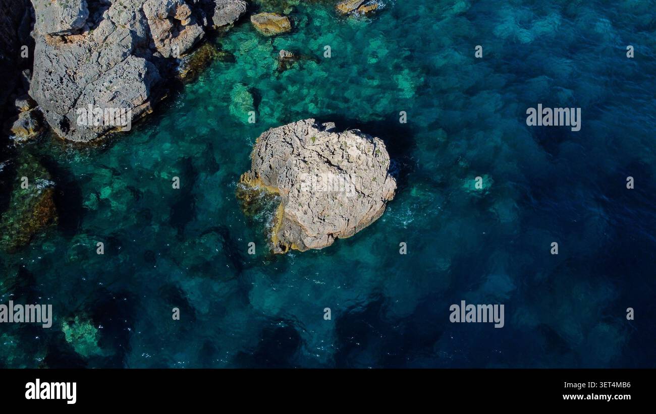 Il mare Adriatico mostra acque cristalline e una roccia sommersa dal punto di vista di un drone aereo, ideale per viaggi e temi naturalistici Foto Stock