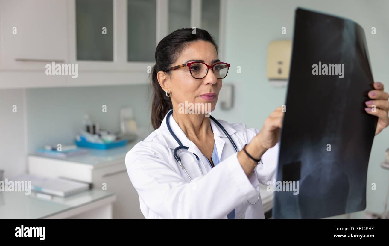 Medico maturo concentrato che fa ricerca medica per pazienti con trauma Foto Stock