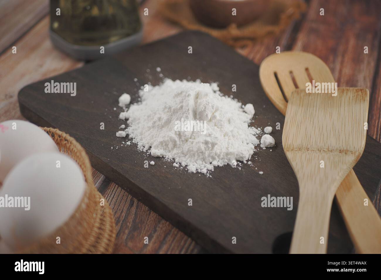 Cucinare con farina e uova su un tavolo da cucina in legno Foto Stock