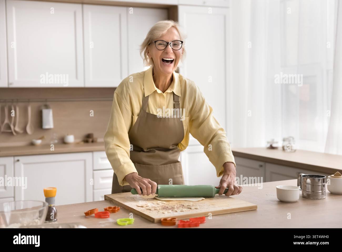 Donna felice che prepara il dessert da sola in cucina moderna Foto Stock
