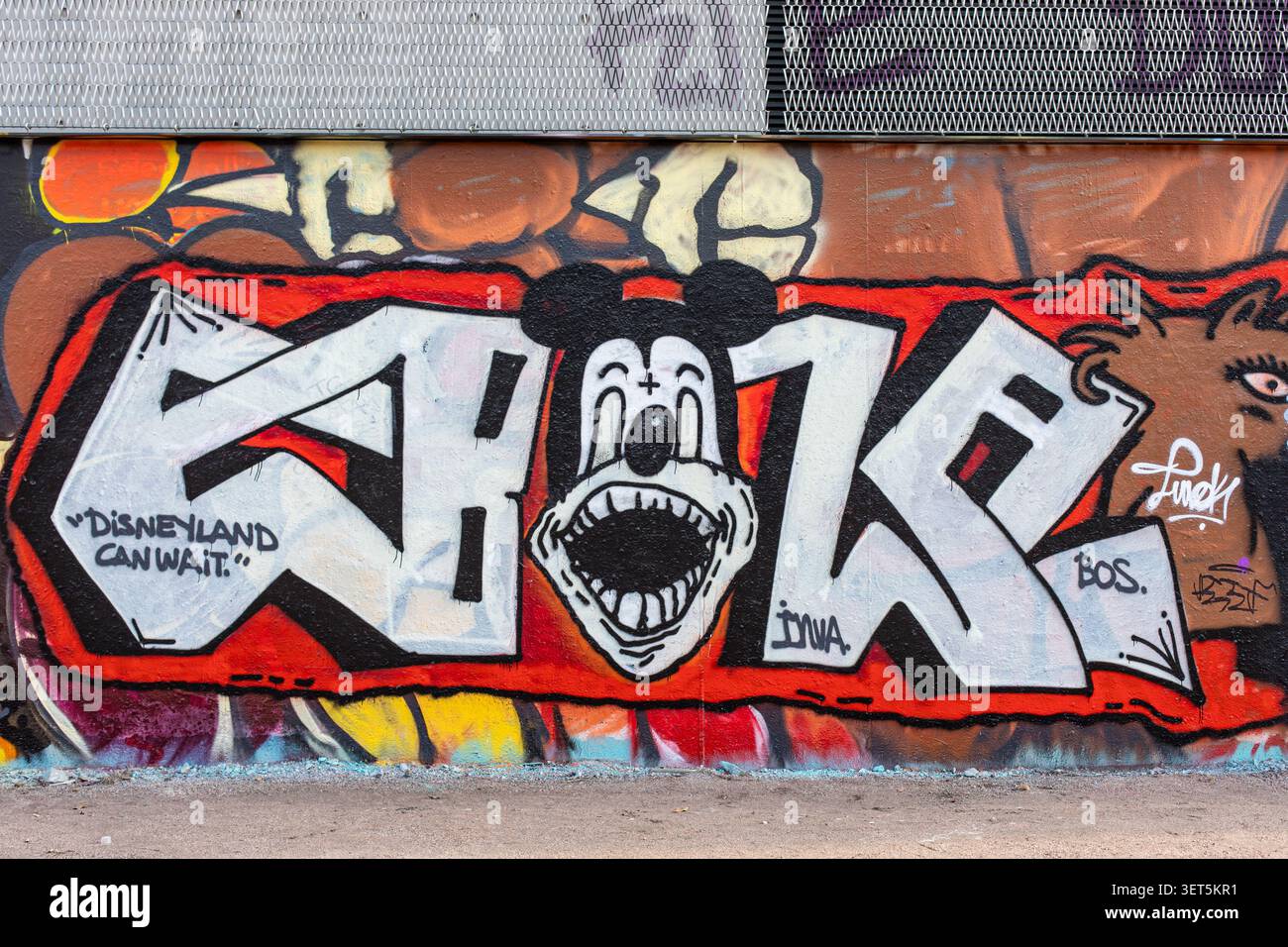 Graffiti murali di Street art che scrivono Ebola, con un personaggio simile a Disney sul muro dei graffiti Suvilahti nel quartiere Sörnäinen di Helsinki, Finlandia Foto Stock