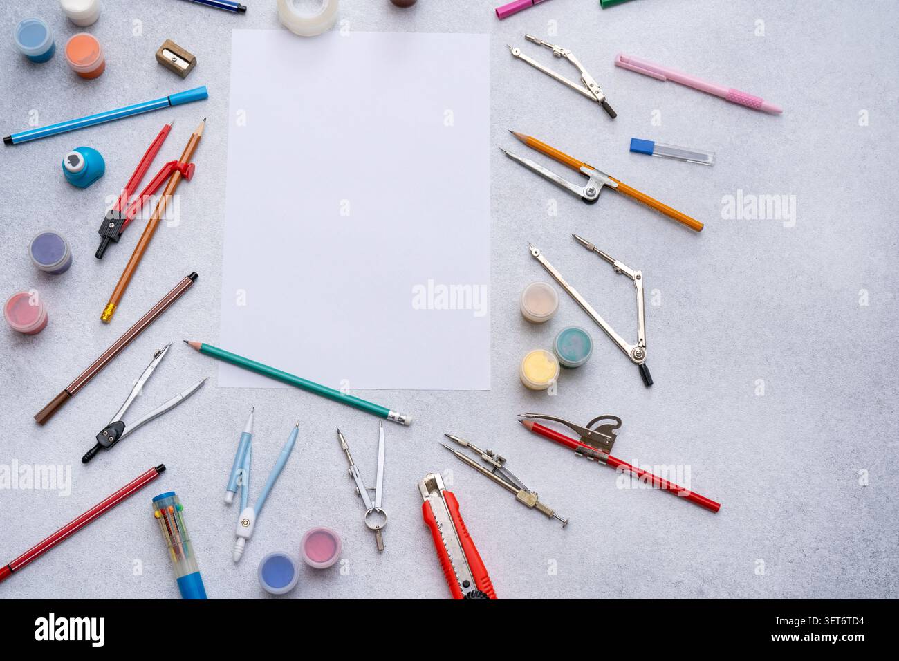 Area di lavoro dello studio tecnico con white paper vuoto, varie forniture per tornare a scuola. Disegna pennelli, matite compasso da disegno attrezzi per la cartoleria Foto Stock