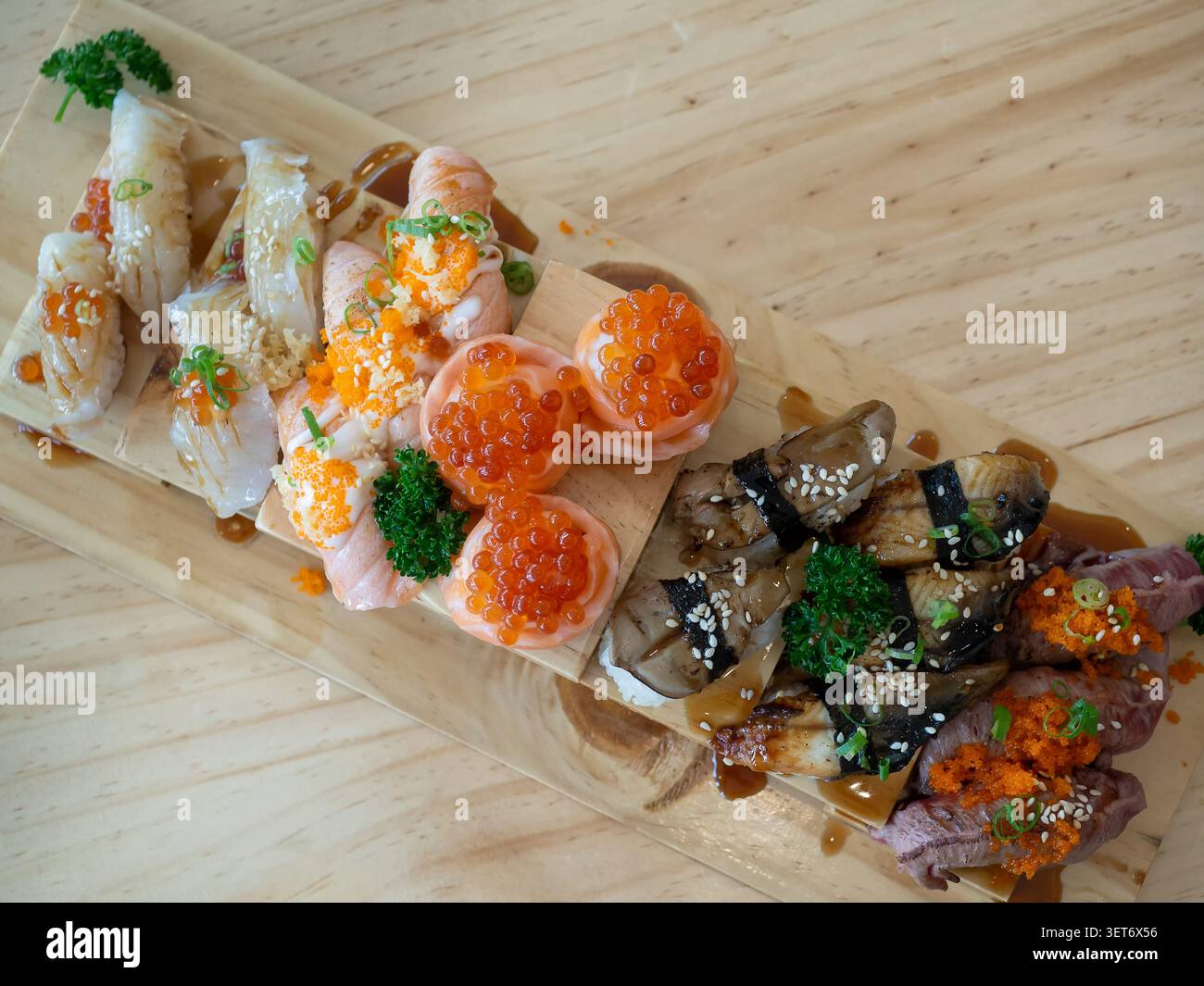 Vista dall'alto di un grande pasto con sushi assortiti e vari su un vassoio di legno nel ristorante giapponese. Cibo giapponese. Foto Stock