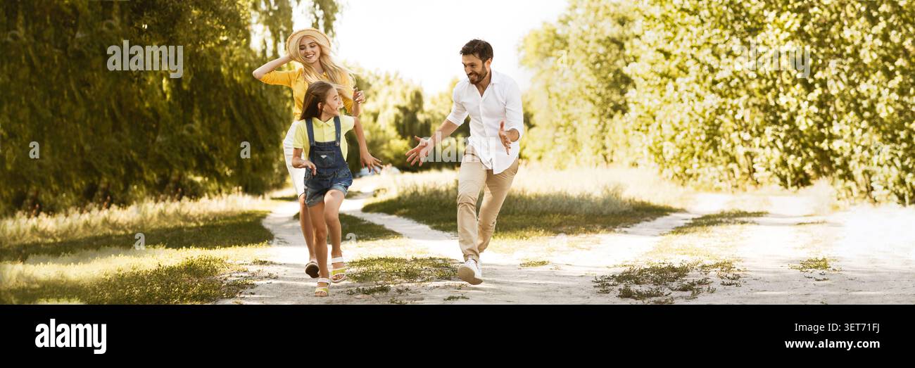 Felice ragazza acceso dai suoi genitori, avente picnic in campagna Foto Stock