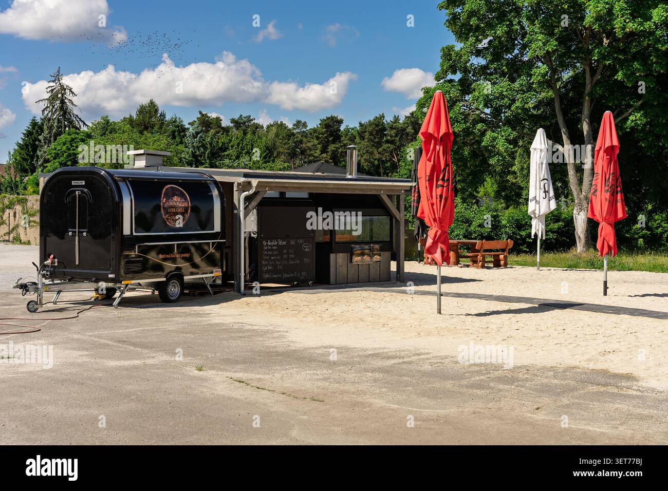 SENFTENBERG, GERMANIA - 6 GIUGNO 2026: Caffè sul lago chiuso a Senftenberger SEE con ombrelloni e stand gastronomico. Foto Stock
