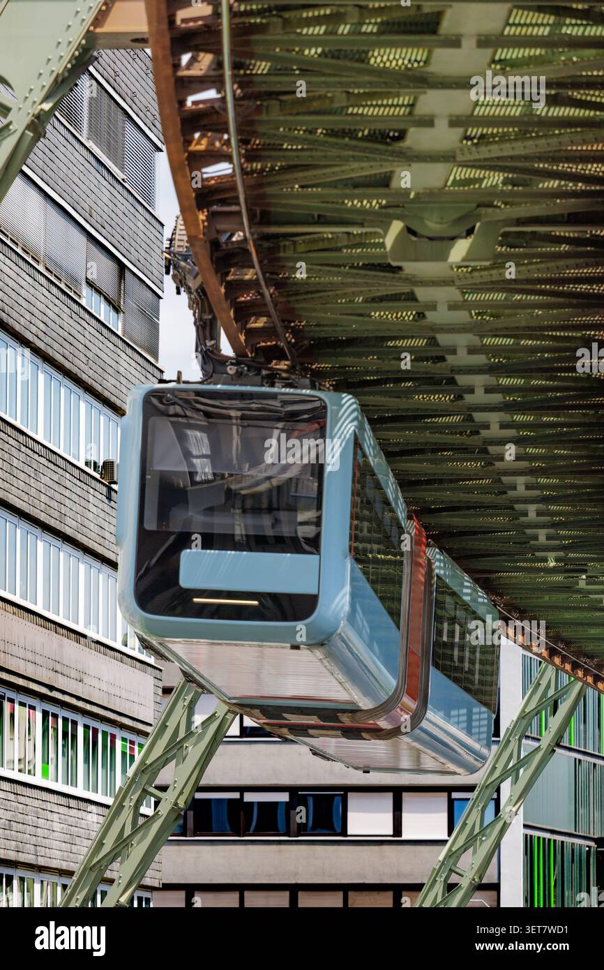 Treno monorotaia sospeso che viaggia attraverso la moderna rete di trasporto urbano Foto Stock