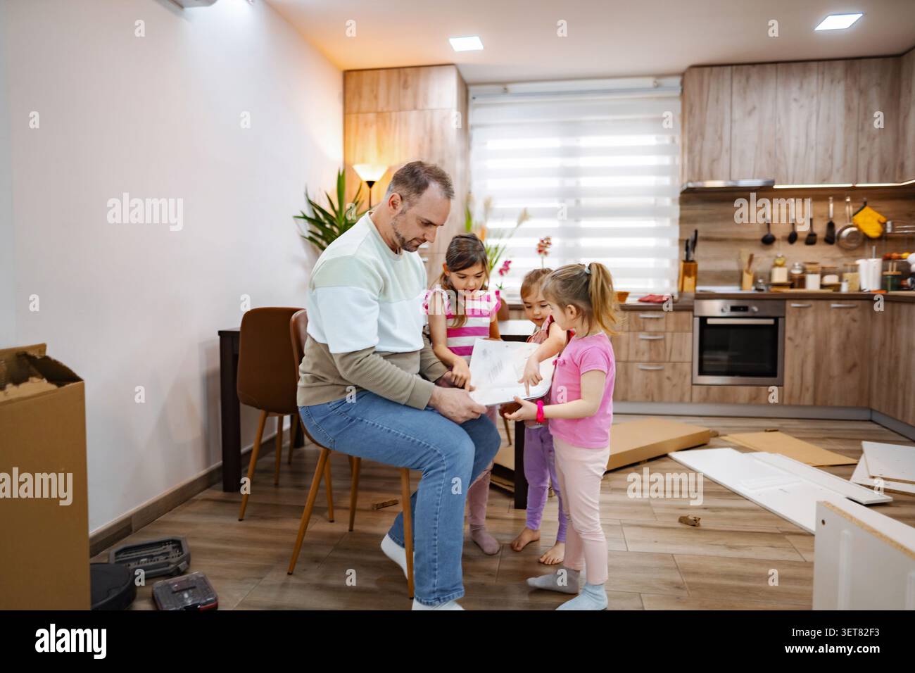 Il tempo di legame familiare come padre e figlie assemblano un nuovo progetto Foto Stock