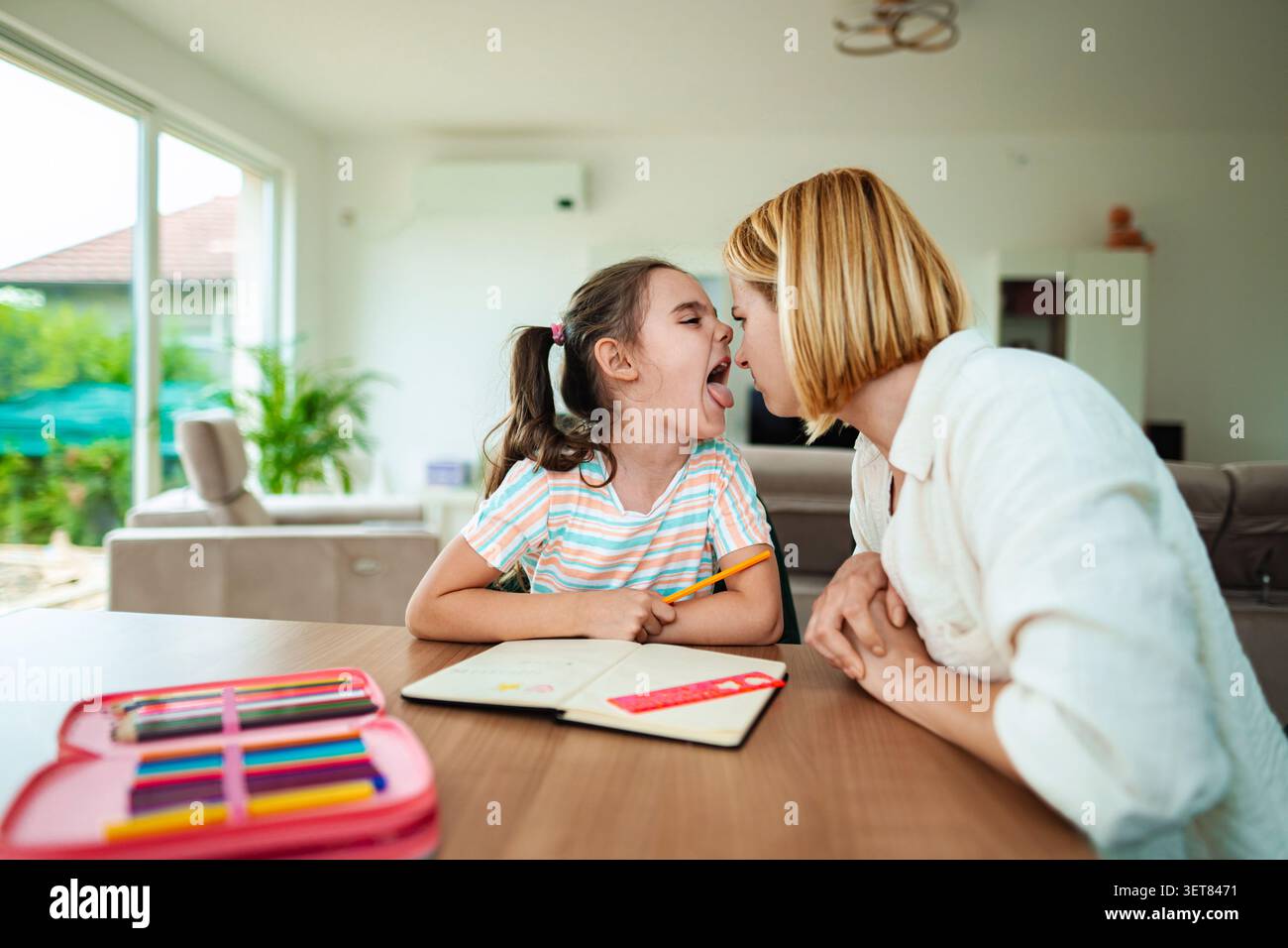 Un momento giocoso di legame tra madre e figlia Foto Stock