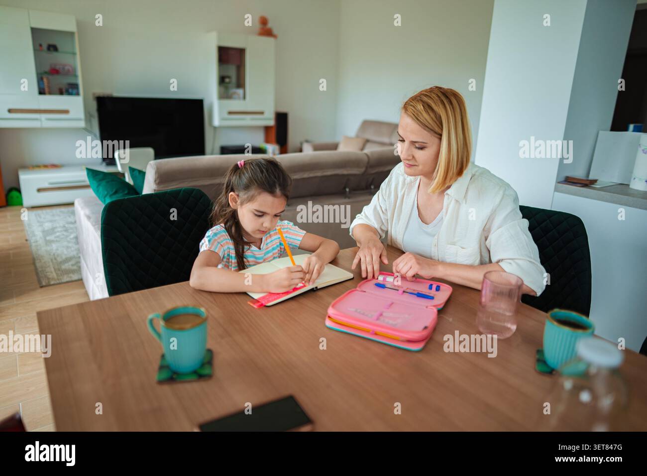 Mamma e figlia si divertono a fare i compiti insieme a casa Foto Stock