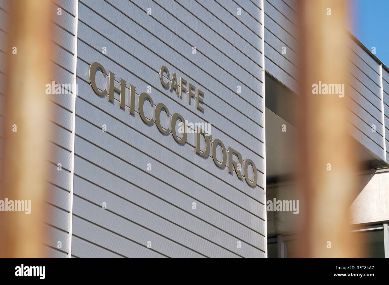 Balerna, Ticino, Svizzera - 17 giugno 2026: Vista ravvicinata dell'iconico logo aziendale Caffe Chicco d'Oro dorato sull'esterno della sede centrale. Foto Stock