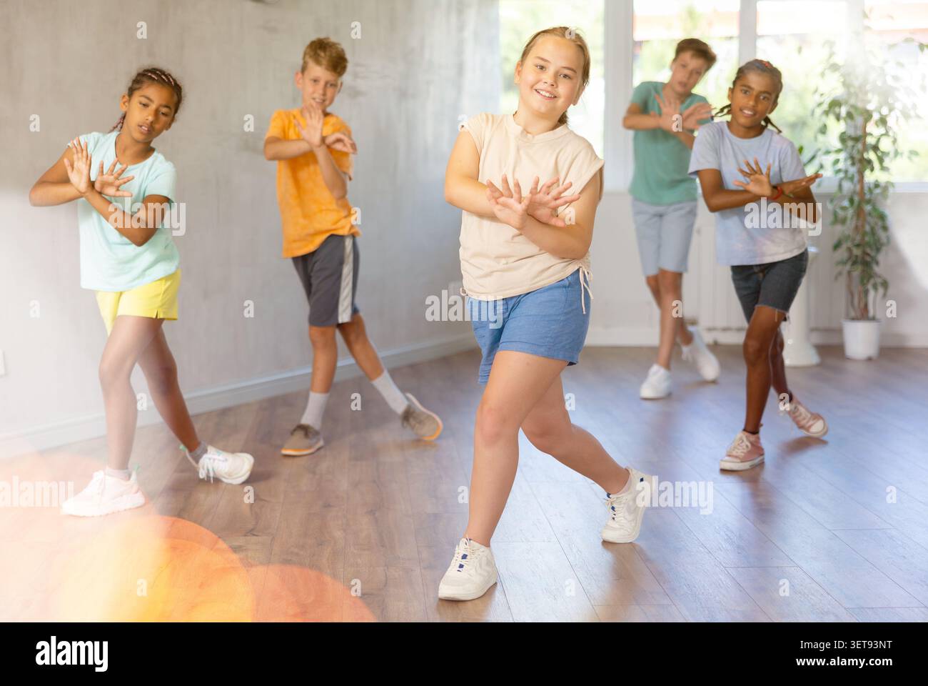 Sorridente tra una ragazza che impara danze dinamiche moderne in una lezione di coreografia Foto Stock
