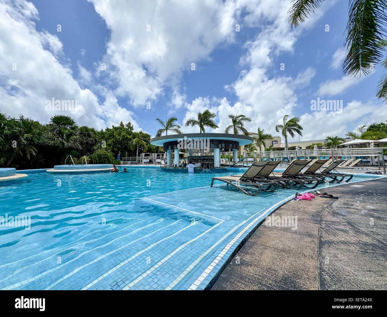 Cancun, Messico – 16 giugno 2026: piscina del resort e sdraio sotto nuvole tropicali al The Grand at Moon Palace. Foto Stock
