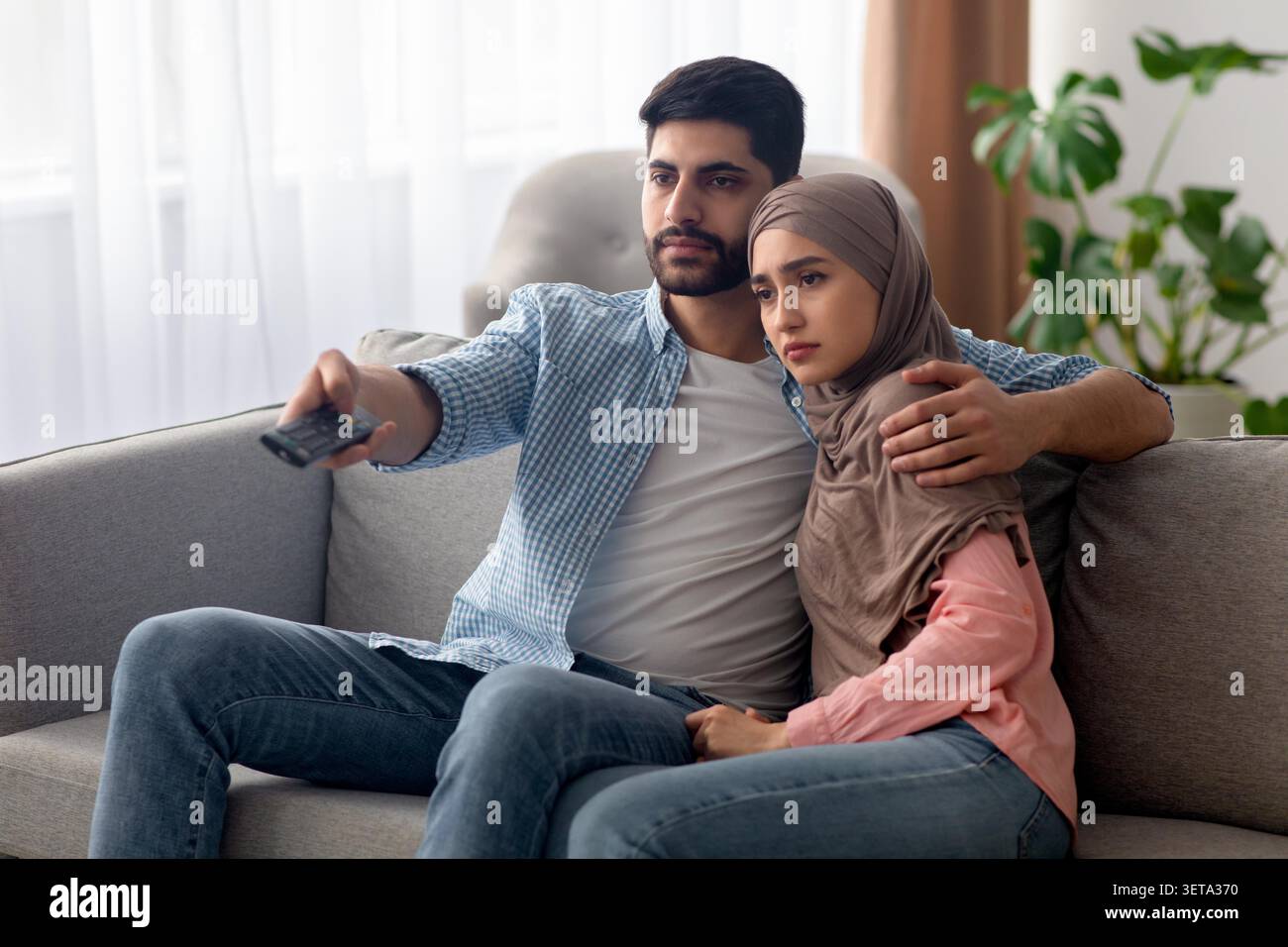 Coppia che guarda film insieme sul divano, giovane uomo e donna, accogliente salotto Foto Stock