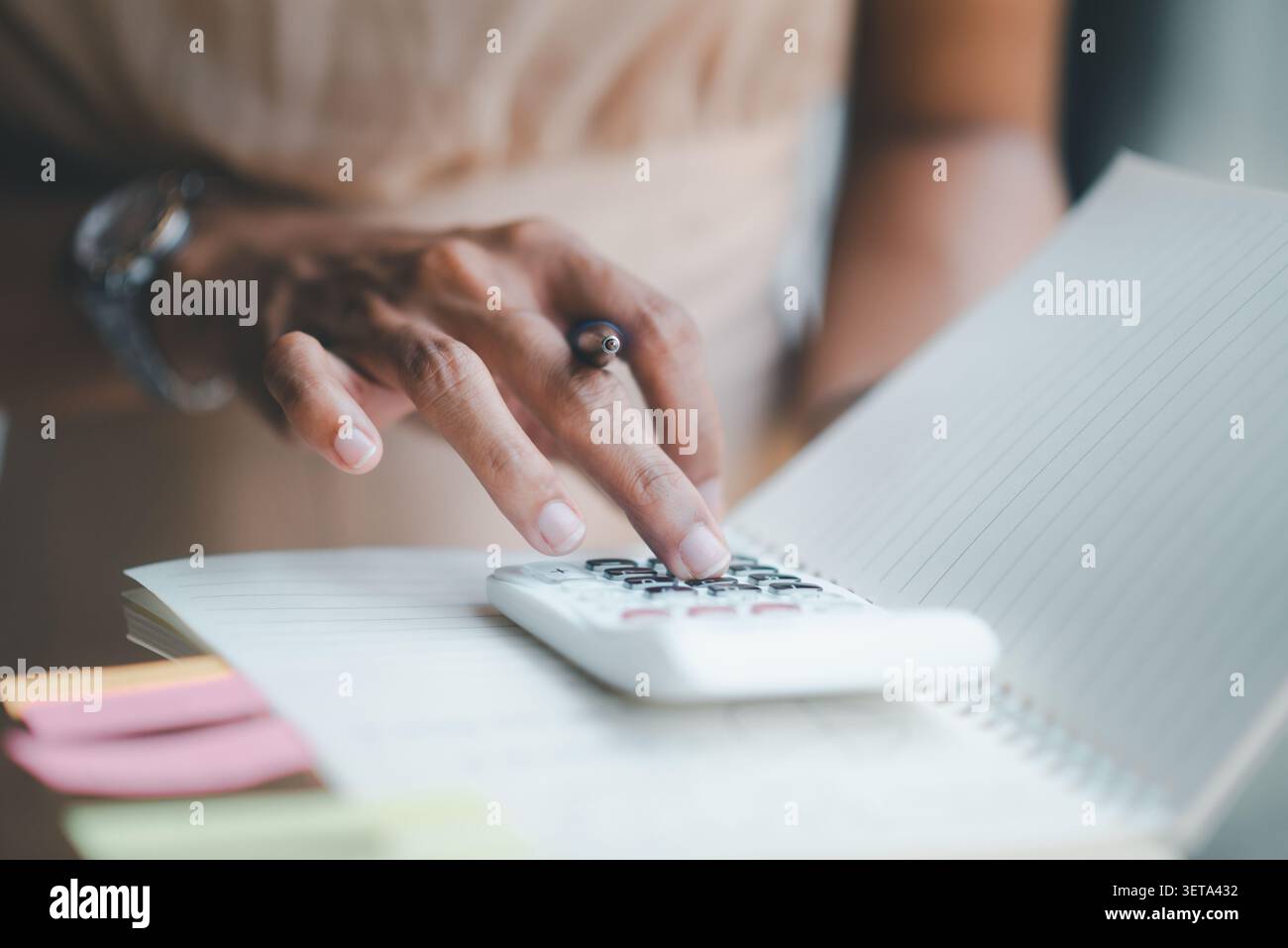 Calcolatrice per primo piano su quaderno con appunti adesivi, che rappresentano la pianificazione del budget, il flusso di lavoro contabile, il calcolo finanziario, ad esempio Foto Stock