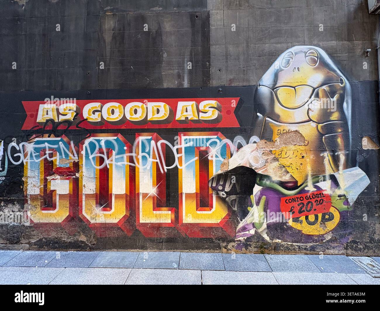 Un colorato murale di Street art dipinto su un muro di mattoni urbani con tipografia grafica e un carattere stilizzato. Foto Stock