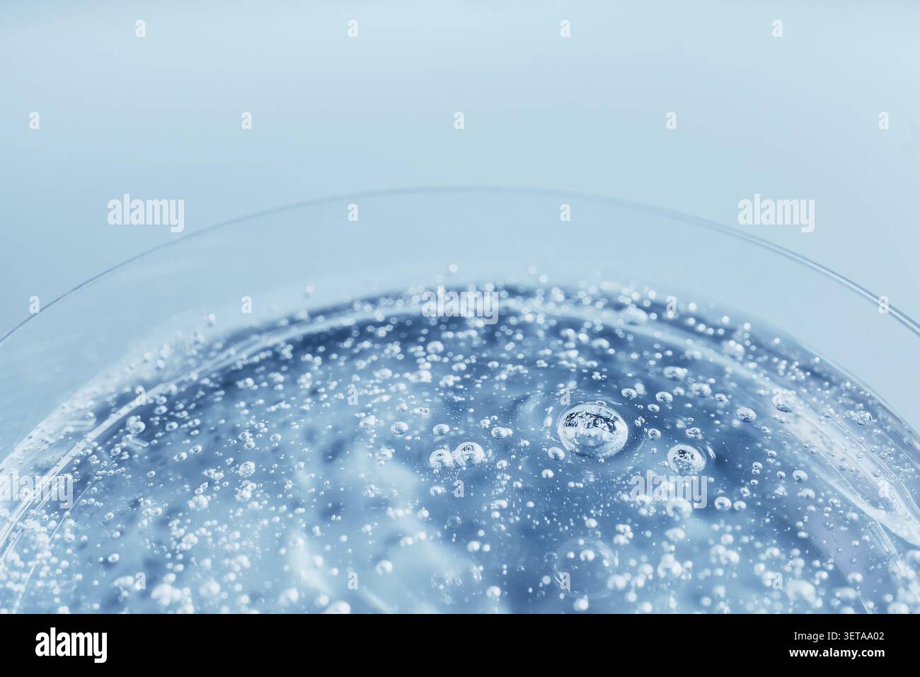 Le bolle diventano un liquido blu scintillante e creano uno sfondo astratto e rinfrescante Foto Stock