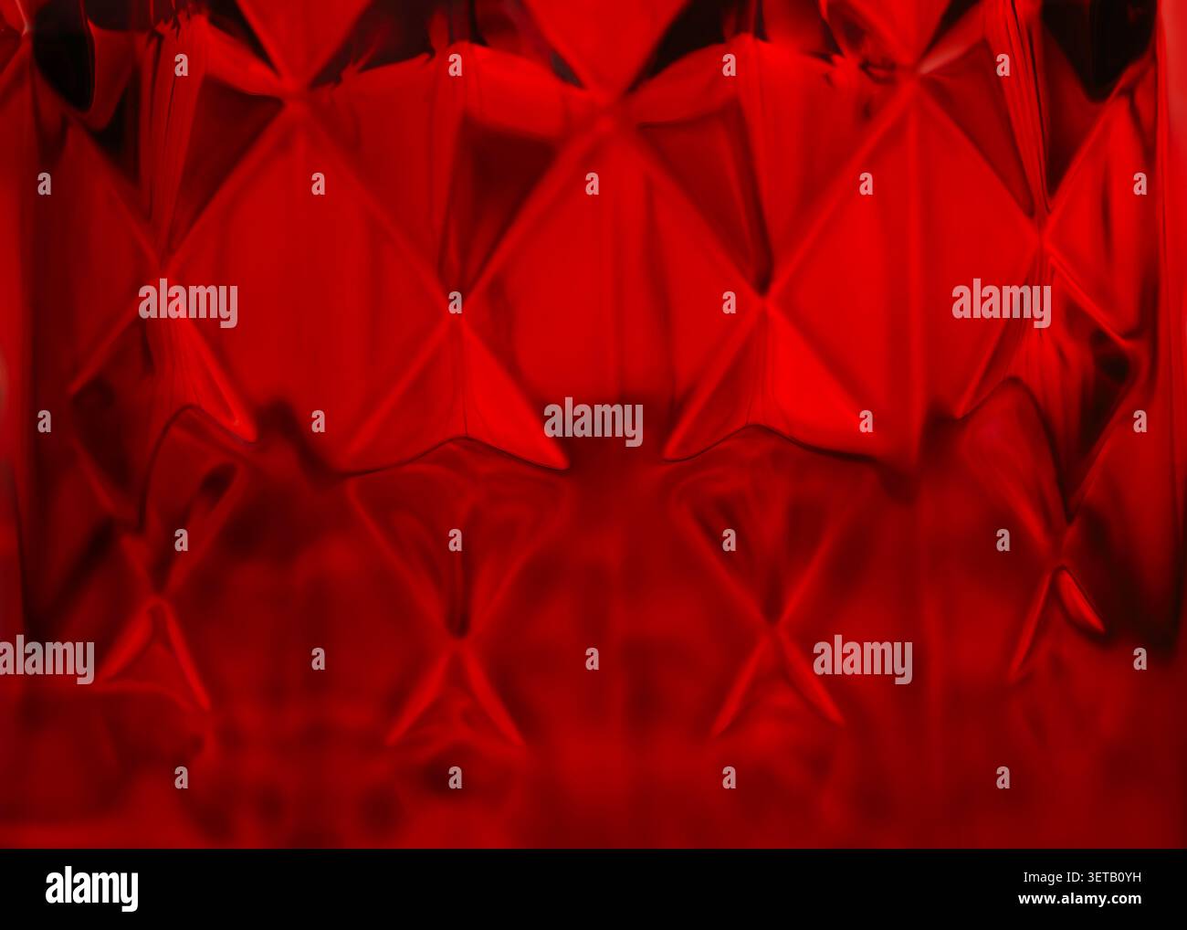 Texture astratta in vetro rosso con motivo geometrico e design a forma di diamante Foto Stock