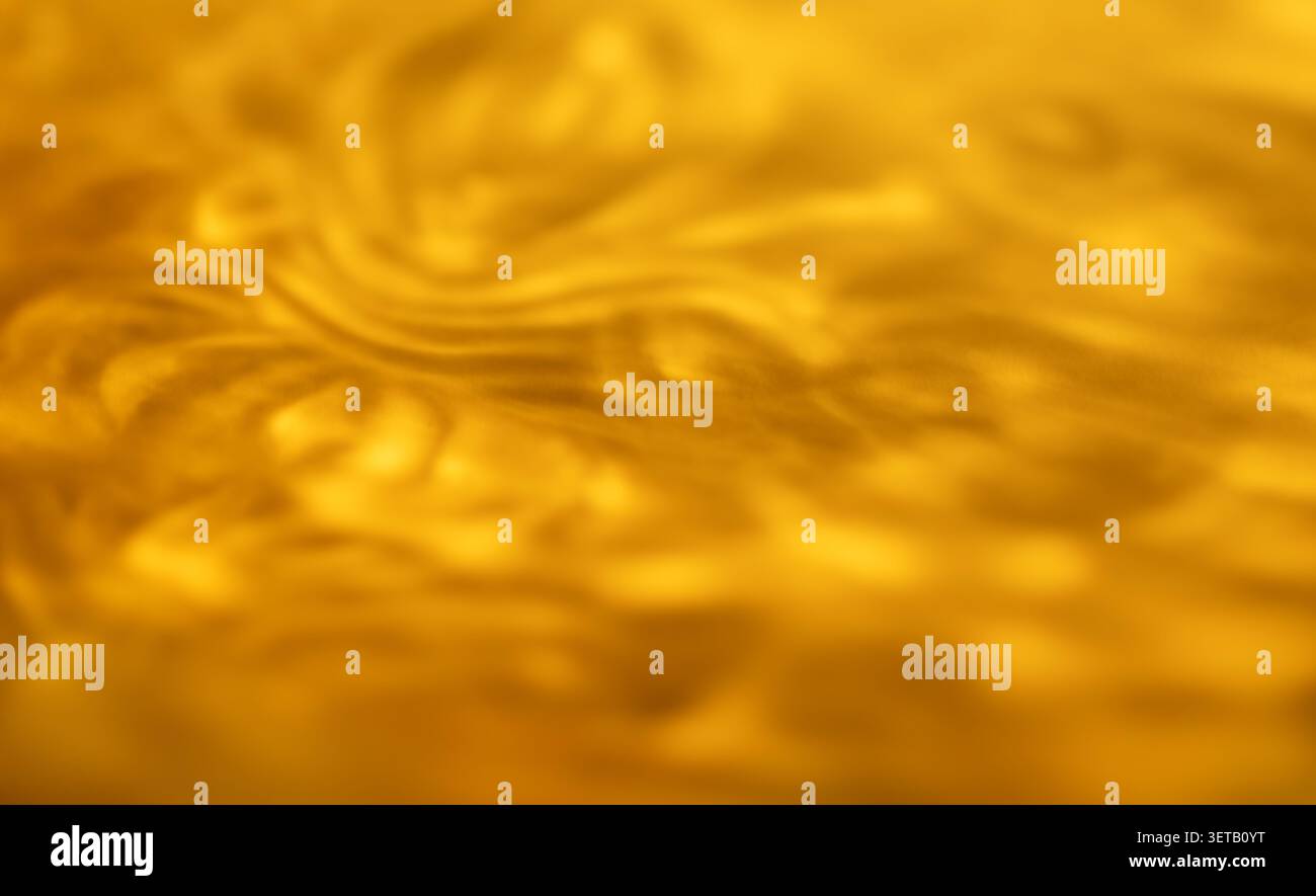 Texture astratta dorata con onde e rotolamenti in primo piano sfocato Foto Stock