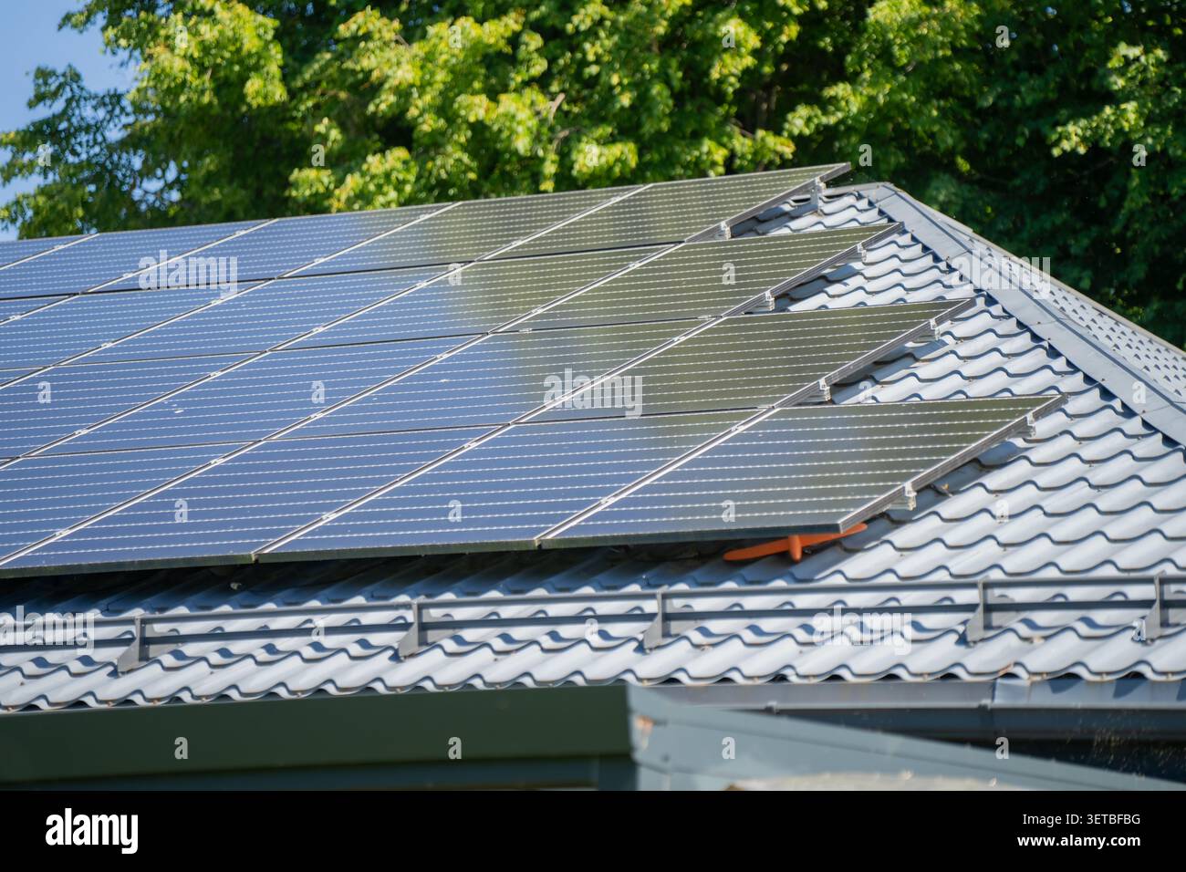 Tecnologia per la casa sostenibile con hardware a microgenerazione solare a energia pulita su un tetto residenziale che mostra la generazione di energia elettrica Foto Stock