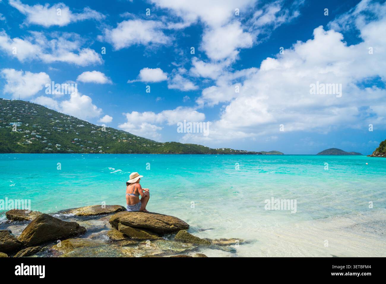 Donna con cappello da sole che gode della vista tropicale Foto Stock