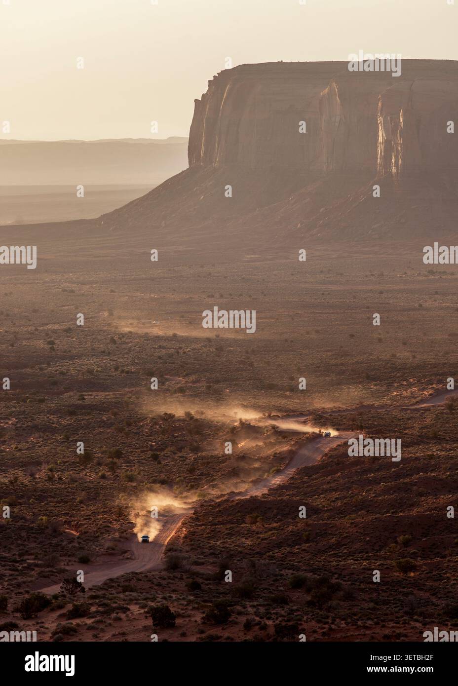 Veicoli fuoristrada che attraversano una polverosa valle desertica Foto Stock