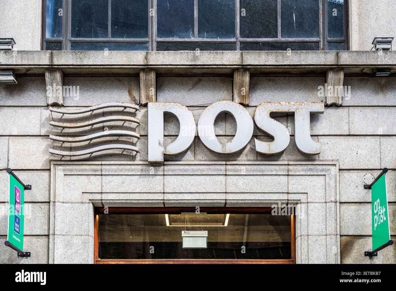 Un ufficio postale con segnaletica esterna sulla facciata in pietra granitica nel centro di Dublino in Irlanda Foto Stock