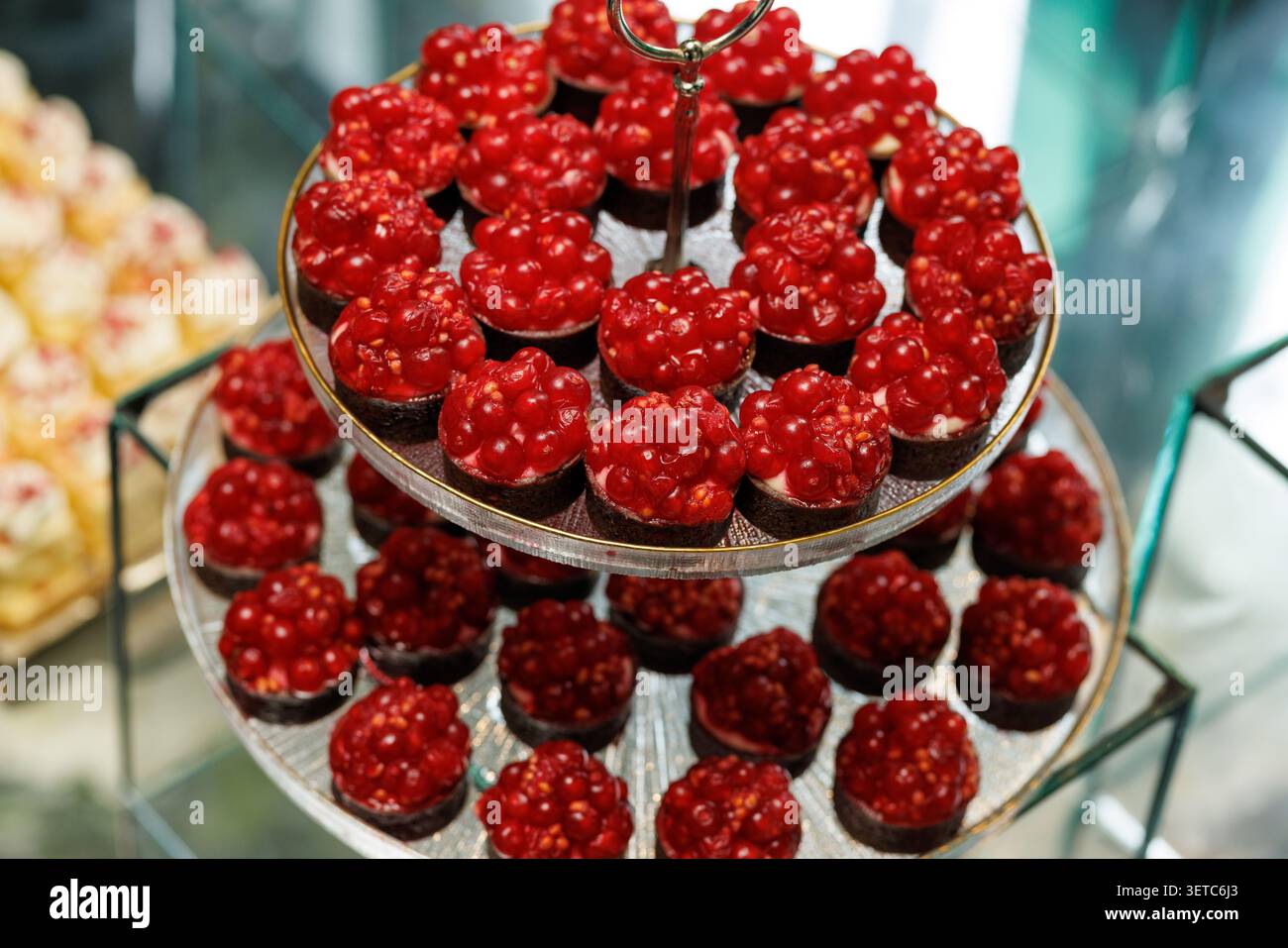 Supporto a vetri a più livelli con tortini dessert ai ribes rossi Foto Stock