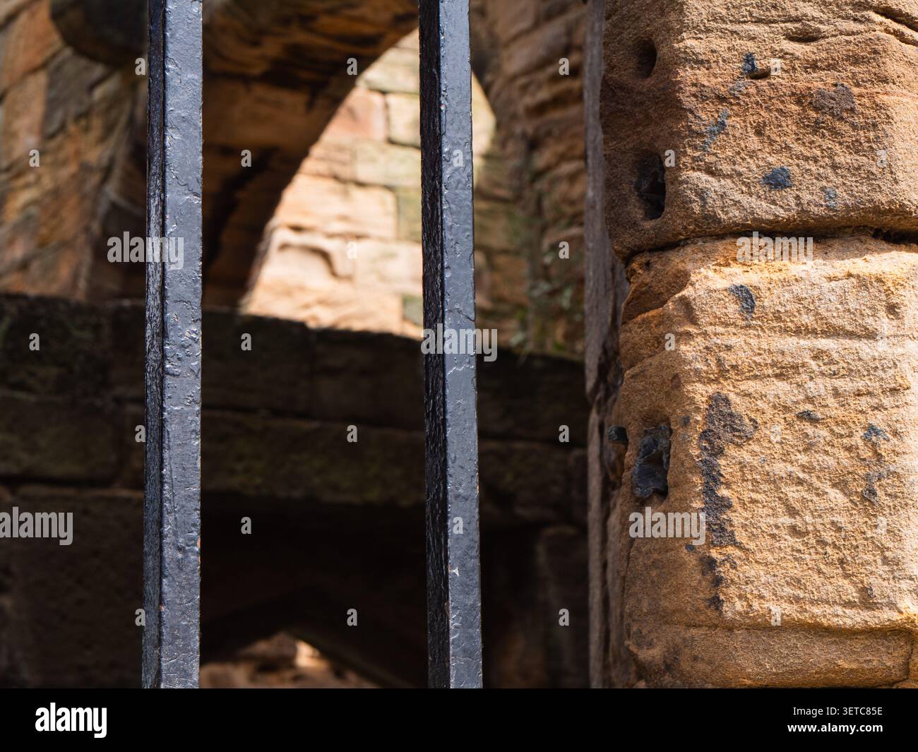 Sbarre di prigione su un muro di pietra Foto Stock