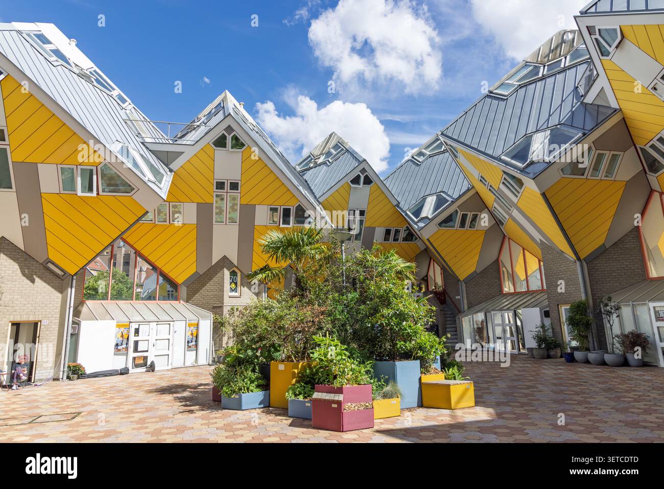 Rotterdam, Paesi Bassi, 10 giugno 2026. Cortile centrale sotto le futuristiche case cubo gialle con piante verdi e strutture geometriche uniche Foto Stock