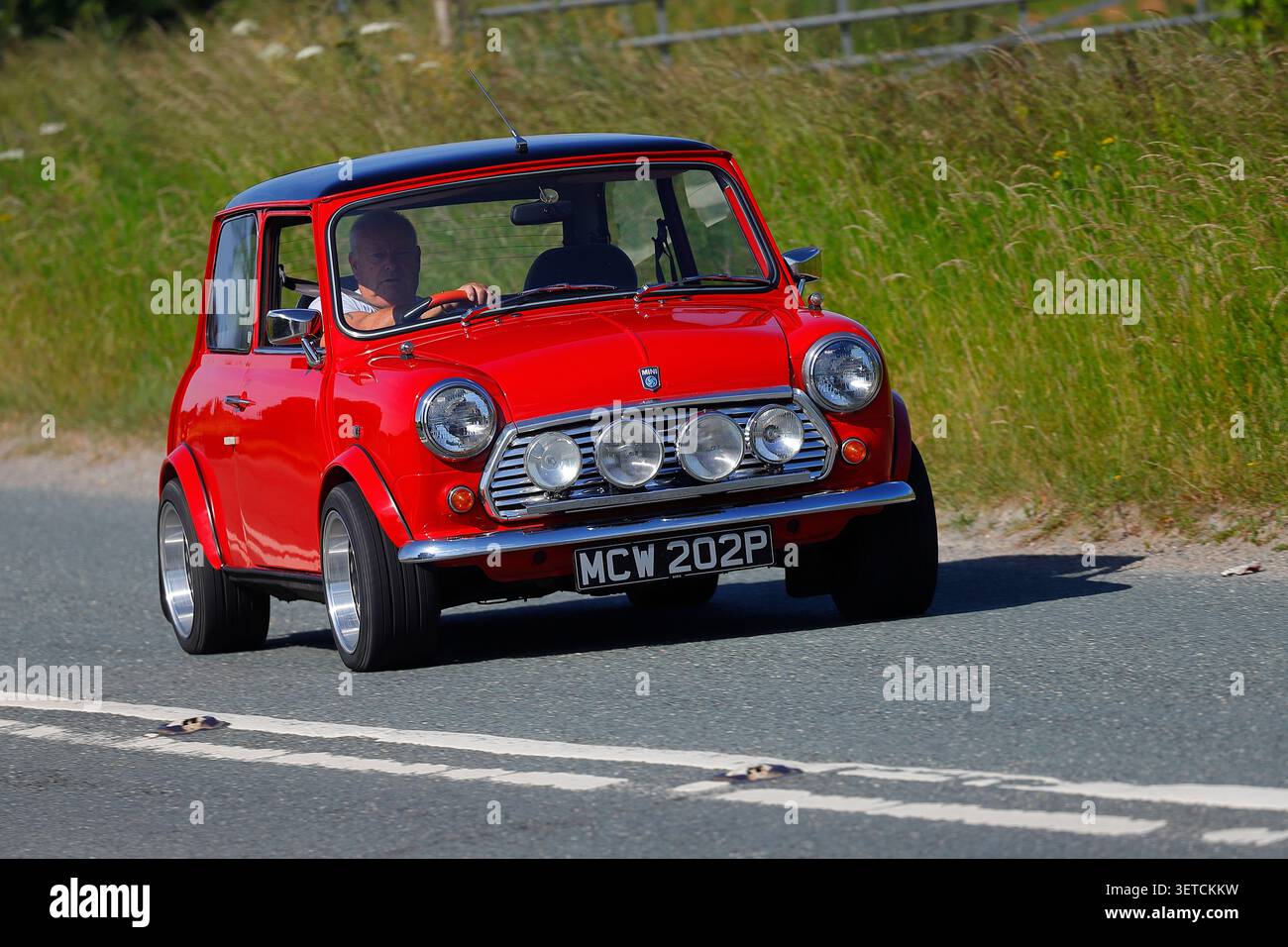 Un Red Classic Mini che viaggia lungo la B1222 vicino a Newthorpe, North Yorkshire, Regno Unito Foto Stock