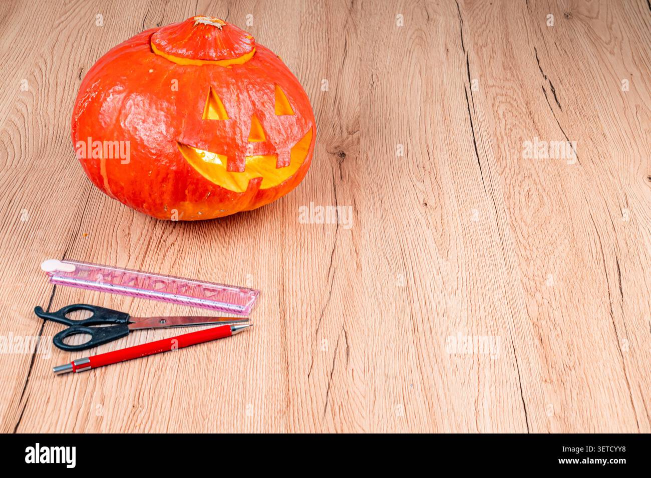 Intagliare il design di una lanterna di Halloween su sfondo in legno Foto Stock