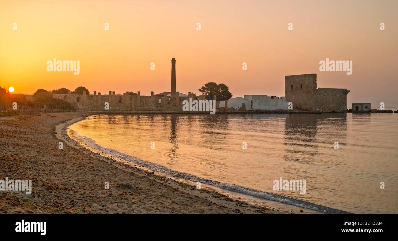 Dawn luce sulle rovine della vecchia fabbrica per la lavorazione del tonno e della torre di guardia medievale a Vendicari, Siracusa, Sicilia, Italia. Foto Stock