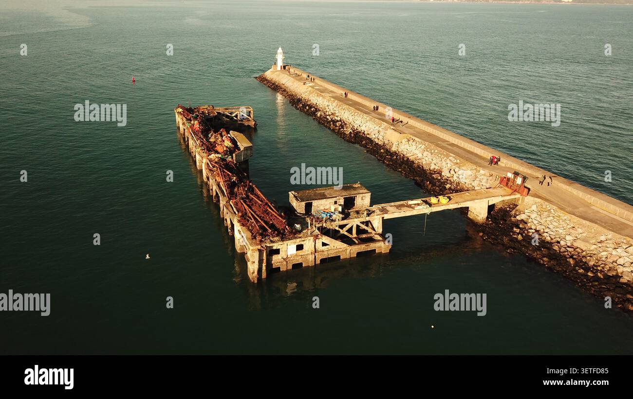 Veduta aerea del Brixham Breakwater con il suo faro e l'adiacente molo abbandonato che si estende nel mare calmo di Brixham, Inghilterra, ONU Foto Stock